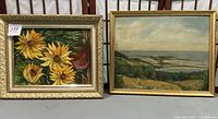 Two framed oil paintings side by side; left is sunflower painting, right is landscape painting.