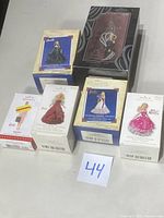 Six boxed Barbie Christmas ornaments from Hallmark Keepsake series, shown on table with lot number 44