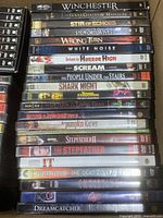 Photo showing a stack of horror DVDs including Winchester, The Texas Chainsaw Massacre, Stir of Echoes, The Stepford Wives, Wrong Turn, White Noise, Return to Horror High, Scream, People Under the Stairs, Shark Night, Return of the Living Dead, Pumpkin Karver, Stepfather series, IT, and Stephen King titles.
