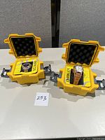 Two Invicta watches in yellow protective cases on a table