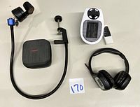 Obsbots camera mounted on a flexible clamp stand with dark grey carrying case, adjacent to Plantronics wireless headphones without wireless adapter, white outlet heater, and remote control.