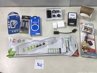 Photo displaying entire lot including packaged USB flash drive, earbuds, lightning cable, mobile device lenses, chargers, power strip, and adapter.