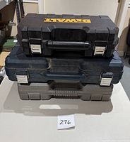 Three stacked hard plastic cases: DeWalt black case on top, blue case in middle, gray case bottom