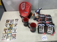 Full view showing all items: ceramic glove, two ceramic mugs, NY Yankees garden gnome, and hockey trading card packs and loose cards.