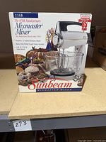 Box front showing Sunbeam Mixmaster 65th Anniversary Mixer model 2360 with glass bowls and dough hooks, highlighting 12-speed electronic motor and included accessories