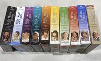 Photo of Little House on The Prairie DVD box sets for seasons 1 through 9 with distinct spine colors and original photos and logos.