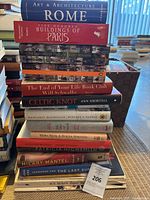 Stack of 15 books of various titles on architecture, history, fiction, and art.