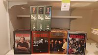 Photo of shelf showing The Godfather Part I, II and III widescreen edition DVD sets and three Sopranos complete seasons DVD sets.
