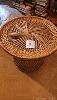 Front angled view showing whole rattan table and woven top with seller auction card