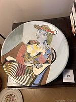 Top view of the large decorative ceramic plate featuring a colorful modernist portrait of a woman inspired by Pablo Picasso's style.