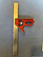 Empire brand tri square with red painted metal head and attached steel ruler with Imperial and Metric markings.