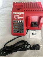 Front angle of Milwaukee battery charger with power cord coiled, showing branding and model details.