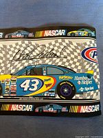 Wallpaper border showing blue NASCAR Car #43 with Pop Secret and Hamburger Helper logos, checkered flag background, and NASCAR logo in design.
