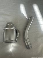 Top-down photo of shower head and elbow showing brushed nickel finish and form.