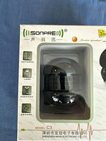 Photo of Sonpre speaker in white retail box showing front window with black spherical speaker visible inside, with logos, model number C3 and other product icons.
