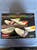 Box showing illustration of the 6 different colored flourish white oval bowls in the set.