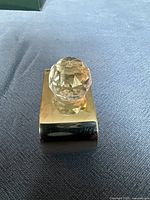 Close-up image of one silverplated napkin ring with a clear faceted crystal bead on top, showing the reflective surfaces and detail.