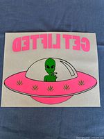 Full view of vintage iron-on transfer showing reversed hot pink 'GET LIFTED' text and pink spaceship with alien inside and weed leaves.