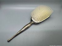 Full view of the Birks sterling silver hairbrush with plastic bristles.