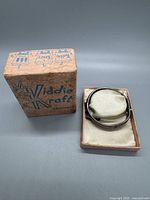 Photo of the vintage sterling silver hinged bangle bracelet inside the original box with a cushioned insert.
