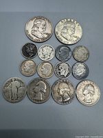 Top-down view showing arrangement of 14 U.S. silver coins including half dollars, dimes, and quarters.