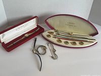 Seven vintage women's wristwatches placed upright and flat, showing different models and colors, all in vintage cases or loose, with measuring tape for scale.