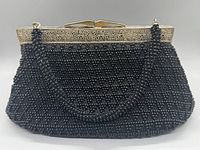 Front view of vintage black beaded evening purse detailing beaded surface and metal frame