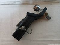 Photo showing overall condition of the 2-inch trailer hitch with visible locking pin attached to the hitch tube and the chrome hitch ball at the end.