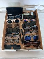 Top view showing a box with an assortment of sunglasses and reading glasses in various colors and frame styles