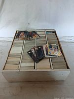 Large white box filled with many NBA trading cards packed in rows and separated by cardboard dividers.