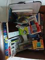 Photo showing the full lot from above, capturing various new office supplies including markers, tape, journal, pens, and carrying case.