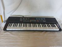 Full front view of the Rock Jam RJ640 electric keyboard showing the 61 keys with note labels and control panel above the keys.