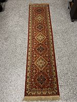 Full length photo of the Persian runner rug showing the complete pattern and fringe at one end.