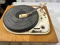 Full view of Garrard 4HF turntable showing overall condition with black rubber platter, plastic tonearm, and white metal base.