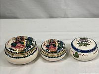 All three hand painted porcelain trinket dishes together, showing the varied colorful fruit and floral designs and different sizes.