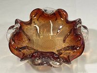 Top and side view of the amber Murano art glass bowl showing bubble texture and ruffled edges.