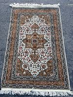 Full view of the Persian style wool area rug laid flat on ground, showing entire multicolor pattern with fringed edges.