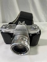 Front view of the Topcon Irex camera showing silver metal body with black leatherette and the UV Topcor lens attached.