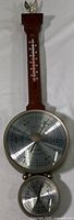 Full view of vintage weather station with wood body, thermometer on top, large circular barometer in middle, and smaller hygrometer below.