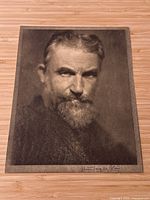 Full view of signed portrait print on wood background showing entire image and signature