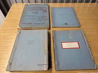 Four blue-bound Cleopatra scripts arranged on a table: two top, two bottom.