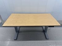 Front view of the standing desk showing rectangular bamboo top and grey metal legs