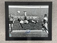 Full shot of framed black and white photograph showing Pelé performing overhead kick, signature at bottom center, Beckett authentication sticker visible