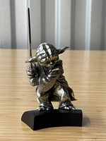 Front side of Yoda pewter figurine showing the iconic pose with the lightsaber held in both hands, emphasizing detail in face and robes.
