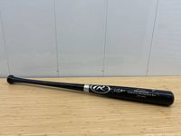 Full-length side view of the black wood bat showing Rawlings logo and printed anniversary text