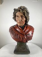 Frontal view of plaster bust sculpture depicting Aunt Jerusha, showing detailed facial features, bonnet, and red shawl.