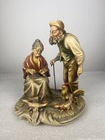 Full view of Antonio Borsato porcelain figurine showing elderly couple with chickens on a rounded decorative base.