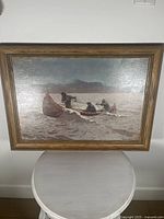 Full front view of the framed reproduction painting depicting three men in a canoe on rough waters.