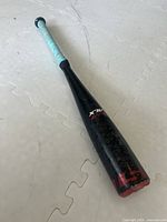 Full length view of a black Easton baseball bat with turquoise grip tape and minor surface scratches on the barrel
