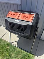 Front view of VIVOSUN 43 gallon dual-chamber tumbler composter with two orange lids and black body mounted on metal stand.